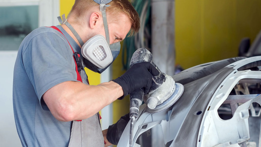 image of man sanding vehicle body panel