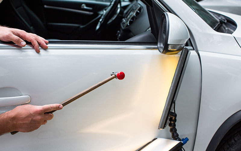 image of person performing paintless dent repair